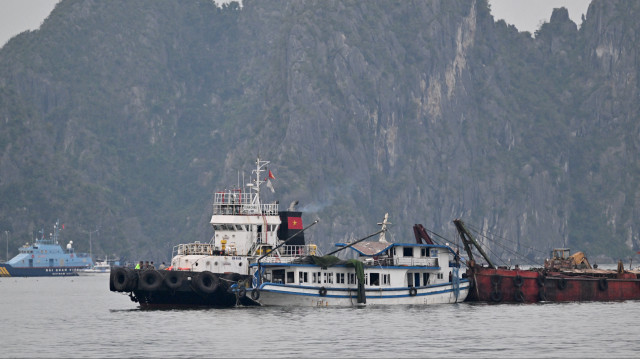 Le bateau de tourisme (C) qui a chaviré est remorqué vers le port de la baie de Ha Long, dans la province de Quang Ninh, le 20 juillet 2025. Un bateau de tourisme transportant des familles dans la baie d'Ha Long, au Viêt Nam, a chaviré lors d'une tempête le 19 juillet après-midi, faisant au moins 34 morts, selon les médias d'État, alors que les sauveteurs se démènent pour retrouver les disparus.