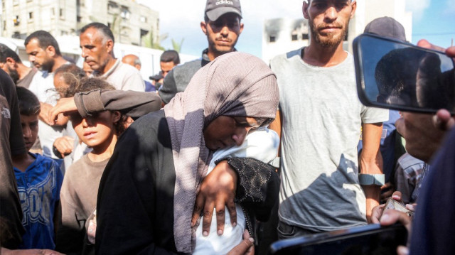 La mère de Yahya Fadi al-Najjar, un nourrisson mort de malnutrition, pleure en tenant son corps lors des funérailles au complexe médical Nasser à Khan Yunis, dans le sud de la bande de Gaza, le 20 juillet 2025.