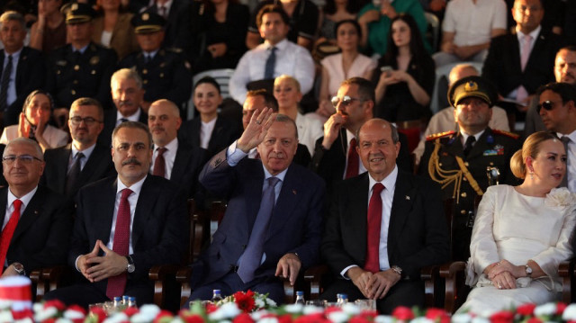 Le ministre turc des Affaires étrangères Hakan Fidan (G), le président turc Recep Tayyip Erdogan (C) et le dirigeant chypriote turc Ersin Tatar assistent à un défilé militaire commémorant l'invasion de Chypre par la Türkiye en 1974 et l'établissement de la "République turque de Chypre du Nord" (RTCN) autoproclamée, dans la partie nord de la capitale de l'île, Nicosie, le 20 juillet 2025.