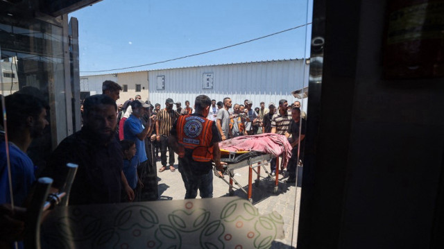Des médecins palestiniens transportent le corps d'une victime d'une frappe israélienne sur un appartement du camp de réfugiés de Nuseirat, à l'hôpital Al-Awda, dans le centre de la bande de Gaza, le 19 juillet 2025.