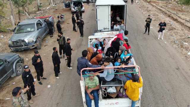 Cette vue aérienne montre un camion transportant des membres évacués de la communauté bédouine s'arrêtant à un point de contrôle mis en place par les forces gouvernementales syriennes le long d'une route à Taarah, dans la province de Suwayda, dans le sud de la Syrie, en direction de Daraa, le 21 juillet 2025.