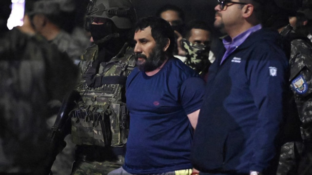 Le trafiquant de drogue Adolfo Macias, alias Fito, est escorté par le ministre de l'Intérieur équatorien John Reimberg (à droite) et des militaires à son arrivée à la base aérienne de Guayaquil, en Équateur, le 25 juin 2025, après sa recapture à Manta, dans la province de Manabi.