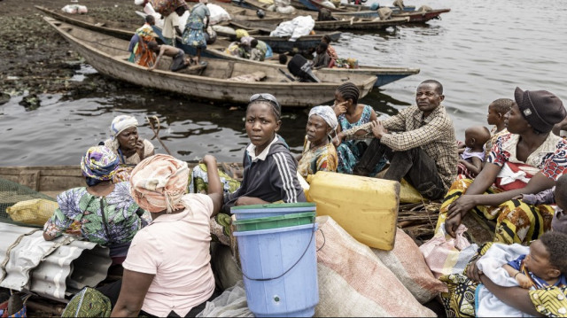 Des personnes déplacées à l'intérieur du pays montent à bord de pirogues après avoir quitté le camp de déplacés de Bulengo, à Goma, le 11 février 2025.