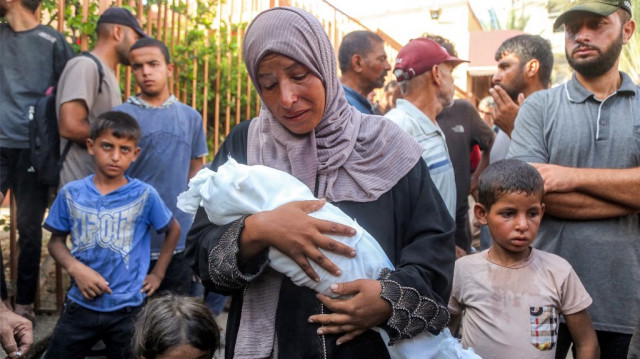 La mère de Yahya Fadi al-Najjar, un nourrisson mort de malnutrition, pleure en tenant son corps lors des funérailles au complexe médical Nasser à Khan Yunis, dans le sud de la bande de Gaza, le 20 juillet 2025.