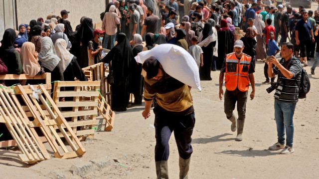 Un Palestinien transporte un sac de farine dans un entrepôt du Programme alimentaire mondial (PAM) de l'ONU dans la rue Al-Jalaa de la ville de Gaza, dans le nord de la bande de Gaza, le 12 juillet 2025.