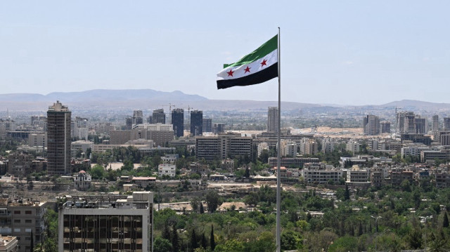 Un grand drapeau syrien flotte au-dessus du parc Tishreen à Damas, le 4 juin 2025.