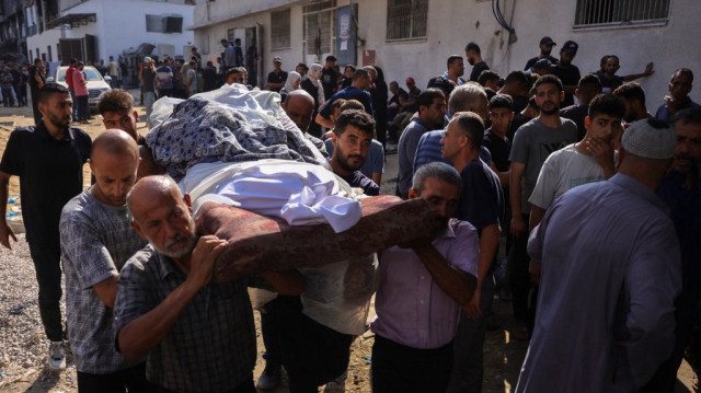 Des Palestiniens transportent le corps d'une victime des frappes israéliennes lors d'un cortège funèbre à l'hôpital Al-Shifa de Gaza City, le 23 juillet 2025. L'ONU a déclaré le 22 juillet que les forces israéliennes avaient tué plus de 1 000 Palestiniens qui tentaient d'obtenir de l'aide alimentaire depuis que la Fondation humanitaire de Gaza, soutenue par les États-Unis et Israël, avait commencé ses opérations fin mai, écartant de fait le système existant dirigé par l'ONU.