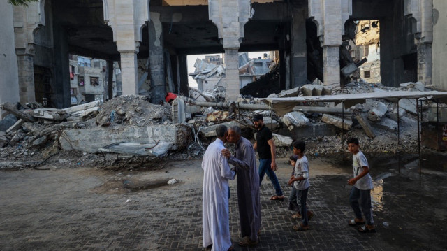 Des hommes se saluent après avoir participé à une prière matinale spéciale le premier jour de la fête musulmane de l'Aïd al-Adha à Nuseirat, dans le centre de la bande de Gaza, le 6 juin 2025, alors que la guerre entre Israël et le mouvement militant palestinien Hamas se poursuit.