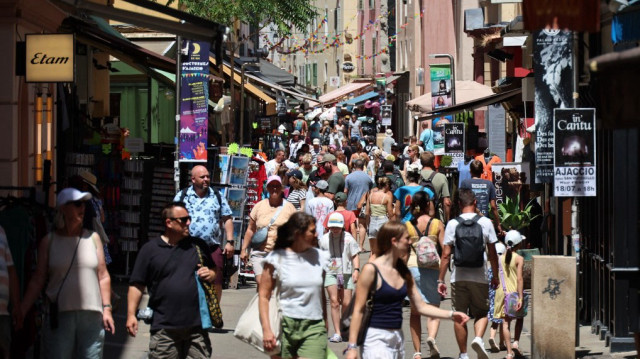 Des piétons marchent dans une rue du centre-ville d'Ajaccio, sur l'île méditerranéenne française de Corse, le 16 juillet 2025.