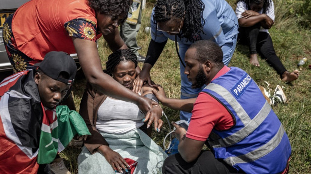 Les membres de la famille et les amis de Boniface Kariuki, un marchand ambulant décédé des suites de ses blessures par balle quelques jours après avoir été abattu par la police kenyane lors de manifestations nationales contre les violences policières et la politique du gouvernement, sont assistés par des secouristes après s'être effondrés lors de ses funérailles dans un village près de Kangema, le 11 juillet 2025.