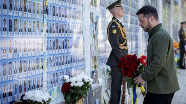 Sur cette photo prise et publiée par le service de presse présidentiel ukrainien le 15 juillet 2025, le président ukrainien Volodymyr Zelensky dépose des fleurs devant le Mur du souvenir des défenseurs ukrainiens tombés au combat lors d'une cérémonie marquant la fête nationale ukrainienne à Kiev.