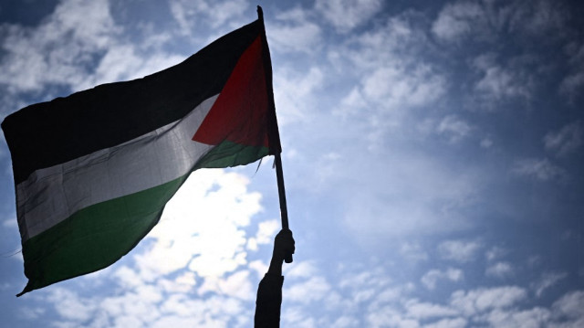 Un manifestant tient un drapeau palestinien lors d'un rassemblement appelé par plusieurs organisations françaises en soutien au peuple palestinien, place de la République à Paris, le 7 mai 2024.