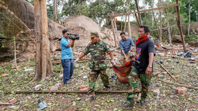 Des soldats cambodgiens transportent le corps d'une victime d'une pagode endommagée par l'artillerie thaïlandaise dans la province d'Oddar Meanchey, le 25 juillet 2025.