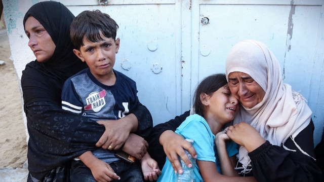 Des femmes et des enfants réagissent après avoir identifié le corps d'un membre de leur famille à l'hôpital Nasser, parmi les Palestiniens tués lors des frappes israéliennes sur le camp de réfugiés d'al-Mawasi et les quartiers est de Khan Yunis, dans le sud de la bande de Gaza, le 24 juillet 2025.