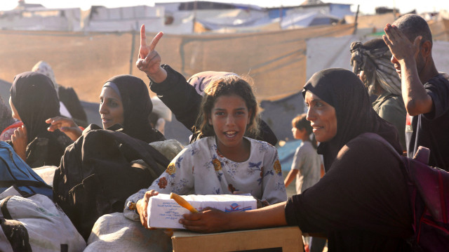 Des Palestiniens se rendent dans la région de Mawasi, à Rafah, le 24 juillet 2025, après avoir reçu une aide humanitaire d'un point de distribution de la Gaza Humanitarian Foundation (GHF) dans le sud de la bande de Gaza. Plus de 100 organisations humanitaires ont averti le 23 juillet qu'une "famine massive" se propageait dans la bande de Gaza et que leurs propres collègues souffraient cruellement de la pénurie.
