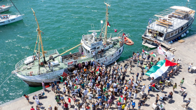 Des personnes se rassemblent autour du navire "Handala" de la Flottille de la liberté avant son départ pour Gaza dans un port de Syracuse, en Sicile, dans le sud de l'Italie, le 13 juillet 2025. Un bateau à destination de Gaza transportant des militants pro-palestiniens et de l'aide humanitaire a quitté la Sicile le 13 juillet 2025, plus d'un mois après qu'Israël ait arrêté et expulsé les personnes à bord d'un précédent navire, qui transportait une quinzaine de militants.