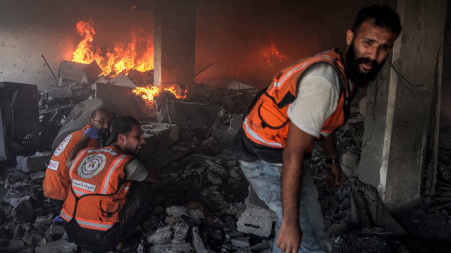 La défense civile palestinienne tente d'éteindre un incendie dans un bâtiment touché par une frappe israélienne dans la ville de Gaza, dans la bande centrale de Gaza, le 2 juillet 2025, au milieu du conflit en cours entre Israël et le groupe militant palestinien du Hamas.