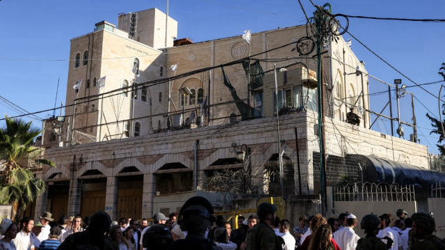Des forces de sécurité israéliennes montent la garde alors que des colons israéliens pénètrent dans la partie palestinienne de la vieille ville et du marché d’Hébron, en Palestine occupée, le 5 juillet 2025.