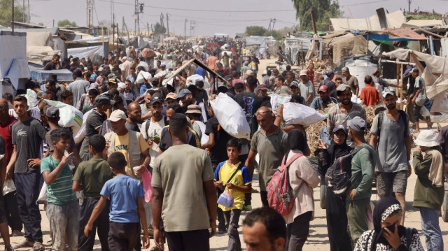 Des Palestiniens transportent de l’aide humanitaire reçue au corridor de Rafah, à Rafah, le 30 juillet 2025.