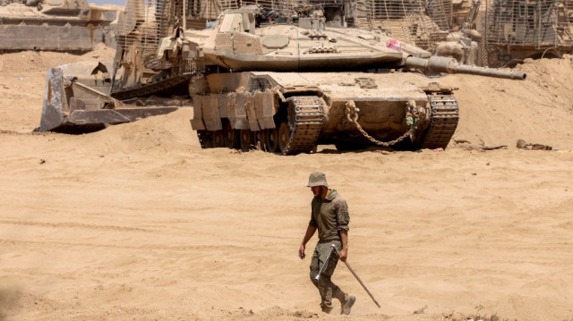 Un soldat de l’armée israélienne marche près d’un char de combat à Gaza, le 29 juillet 2025.