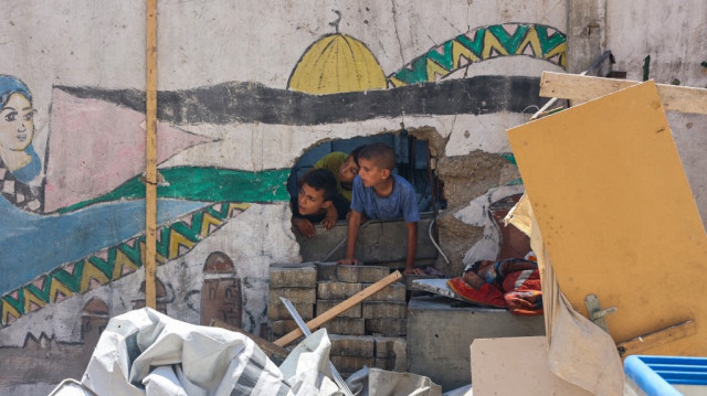 Les enfants vérifient la destruction à l'école Mustafa Hafez, abritant des Palestiniens déplacés par la guerre, après que l'école ait été touchée lors d'une frappe israélienne nocturne à Gaza, le 3 juillet 2025.
