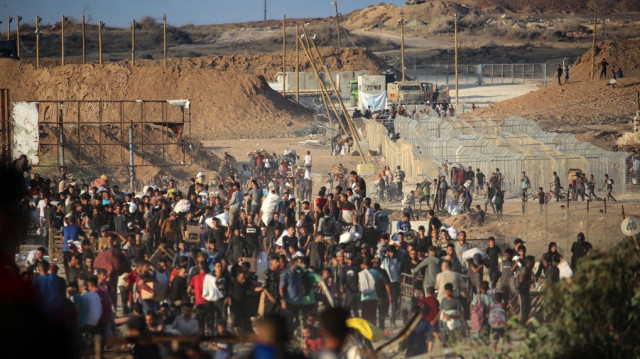 Les Palestiniens se rassemblent à un point de distribution d'aide mis en place par la Fondation humanitaire privée de Gaza (GHF), près du camp de réfugiés de Nuseirat dans la bande de Gaza centrale, le 25 juin 2025.