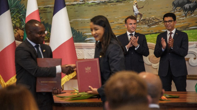 Le ministre français délégué à la Francophonie et aux Partenariats internationaux Thani Mohamed-Soilihi (G) et le ministre malgache des Affaires étrangères Rasata Rafaravitafika (2e G) se serrent la main alors que le président français Emmanuel Macron (2e D) et le président malgache Andry Rajoelina (D) assistent à une cérémonie de signature d'accords de coopération bilatérale entre la France et Madagascar lors de la visite officielle du président Emmanuel Macron à Madagascar, à Antananarivo, le 23 avril 2025.