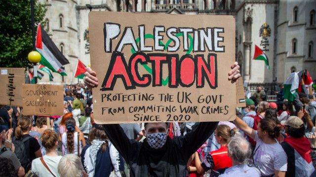 Pro-Palestinian activists stage a solidarity protest outside Royal Courts of Justice as co-founder of Palestine Action Huda Ammori takes Home Secretary to High Court over proscription of the group as terror organization in London, United Kingdom on July 4, 2025. Ammori is seeking to block the proscription coming into effect. Palestine action was banned after 4 members broke into a military airbase and sprayed red paint over airplanes. (AA)