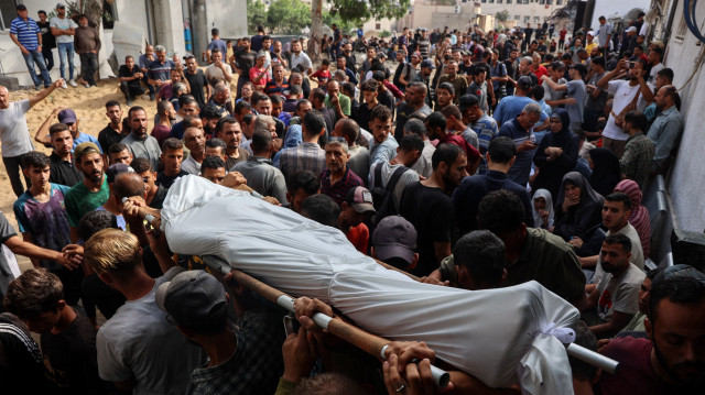 Des Palestiniens portent le corps d'une personne qui aurait été tuée alors qu'elle attendait une aide, lors d'une procession funéraire à l'extérieur de l'hôpital al-Shifa dans la ville de Gaza, le 3 juillet 2025, dans le cadre du conflit actuel entre Israël et le groupe militant palestinien du Hamas.