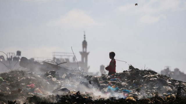 Un garçon palestinien cherche des objets à sauver dans une décharge du camp d'Al-Bureij, dans le centre de la bande de Gaza, le 7 juillet 2025.