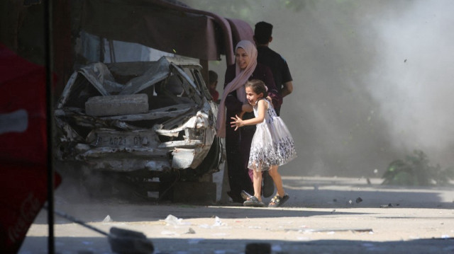 Une mère palestinienne et sa fille se précipitent pour se mettre à l'abri lors d'une frappe israélienne dans le camp d'Al-Bureij, dans le centre de la bande de Gaza.