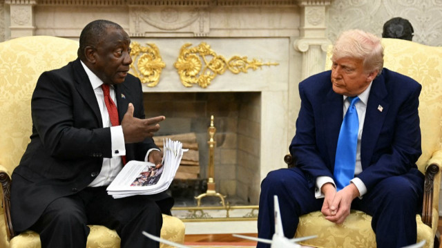 Le président américain Donald Trump remet des documents au président sud-africain Cyril Ramaphosa lors d'une réunion dans le bureau ovale de la Maison Blanche à Washington, DC, le 21 mai 2025.