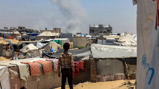 Un enfant palestinien regarde la fumée s'échapper au loin lors d'un bombardement des colons israélien à Rafah, dans le sud de la bande de Gaza.