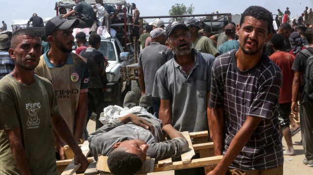 Des Palestiniens courent vers des colis alimentaires largués par un avion militaire à Jabalia, dans le nord de la bande de Gaza, le 9 août 2025.