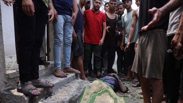 Des personnes récupèrent le corps d'un Palestinien tué lors d'une frappe israélienne, à l'ouest de la ville de Gaza, le 12 août 2025.