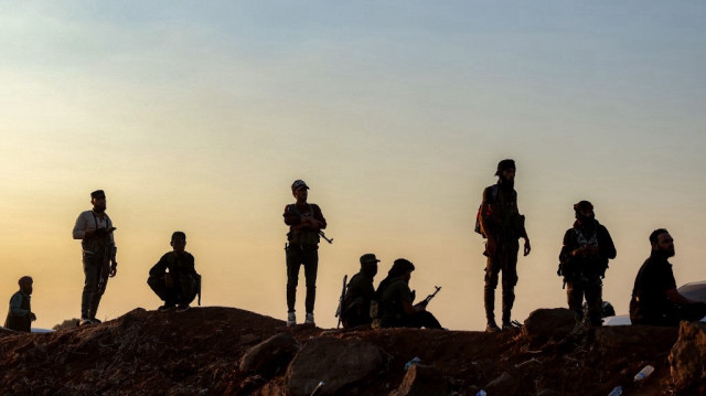 Les forces de sécurité syriennes restent en retrait alors qu'un convoi des Nations Unies évacuant des familles de Sweida traverse la zone tampon à Busra al-Harir, dans la province de Daraa, au sud de la Syrie, le 22 juillet 2025.