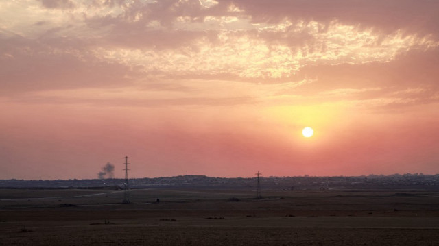 Des nuages de fumée s'élèvent à l'horizon alors que le soleil commence à se coucher sur la bande de Gaza, photographiée depuis un point situé le long de la frontière avec le territoire palestinien assiégé, dans le sud d'Israël, le 10 août 2025.