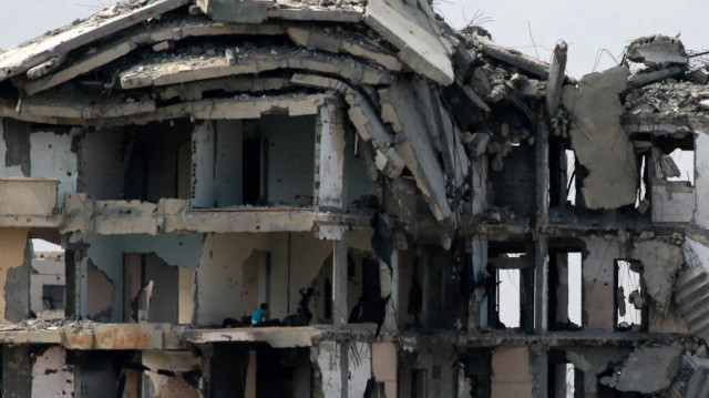 Des enfants palestiniens jouent à l'intérieur d'un bâtiment endommagé par la guerre dans la ville de Gaza, le 8 août 2025.