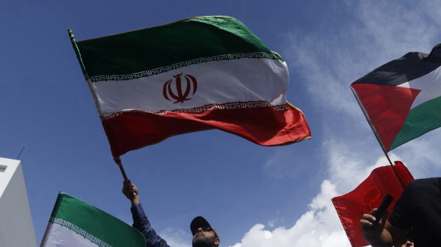 Un homme brandit un drapeau iranien lors d'un rassemblement contre les attaques d'Israël contre l'Iran, en solidarité avec le peuple palestinien et pour appeler à la paix mondiale à Caracas, le 19 juin 2025.