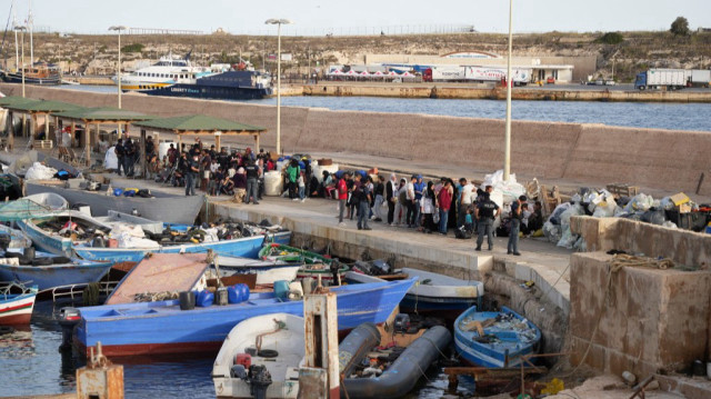 Des migrants attendent au port après leur arrivée sur l'île italienne de Lampedusa.