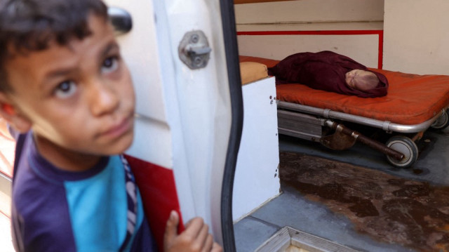 Un jeune garçon se tient près d'une ambulance dans laquelle repose le corps d'un bébé tué, à la suite d'une frappe israélienne qui a touché la maison d'une famille palestinienne à Jabalia, dans le nord de la bande de Gaza, le 23 mai 2025.