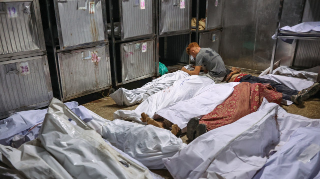 Un Palestinien pleure sur le corps recouvert d'un linceul d'un proche tué la veille alors qu'il cherchait de l'aide près de Zikim, à l'ouest de Beit Lahia, dans le nord de la bande de Gaza, à la morgue de l'hôpital Al-Shifa de Gaza City, le 10 août 2025. 