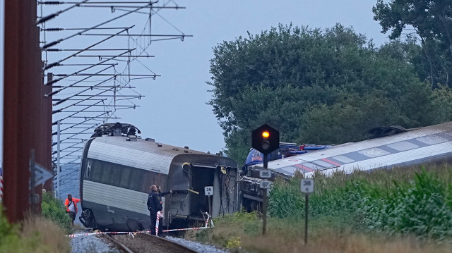 Des policiers inspectent le train de voyageurs qui a déraillé dans un accident alors qu'il se rendait à Soenderborg, dans le village de Bjerndrup, entre Kliplev et Tinglev, dans le sud-ouest du Danemark, le 15 août 2025. Une personne a été tuée et plusieurs autres blessées au Danemark le 15 août 2025 dans une collision entre un train et un véhicule agricole, a indiqué la police.