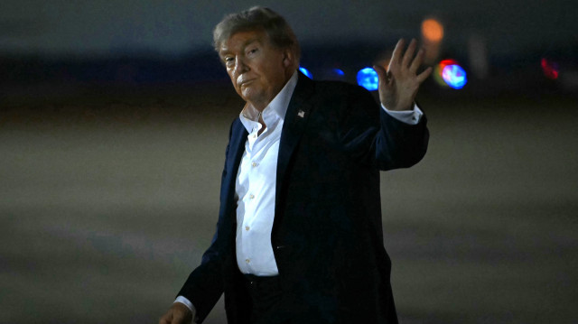 Le président américain Donald Trump salue à son arrivée à la base militaire d'Andrews, dans le Maryland, le 15 août 2025. 