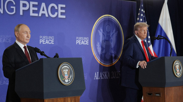Sur cette photo de groupe diffusée par l'agence d'État russe Sputnik, le président américain Donald Trump (à droite) et le président russe Vladimir Poutine tiennent une conférence de presse conjointe à l'issue d'un sommet américano-russe sur l'Ukraine à la base militaire Elmendorf-Richardson à Anchorage, en Alaska, le 15 août 2025.