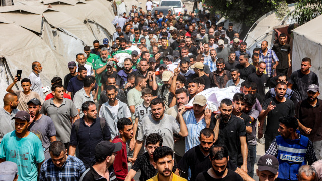 Des personnes en deuil défilent avec les corps des journalistes d'Al Jazeera tués lors d'une frappe israélienne nocturne sur leur tente à Gaza, depuis l'hôpital Al-Shifa jusqu'à leur inhumation au cimetière Sheikh Radwan à Gaza, le 11 août 2025. 