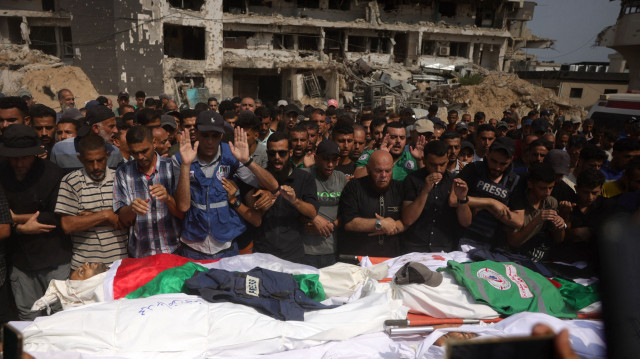 Des personnes en deuil prient lors d'un enterrement collectif pour des Palestiniens, dont des journalistes et un médecin, tués lors d'une frappe israélienne nocturne, devant l'hôpital Al-Shifa à Gaza, le 11 août 2025. Al Jazeera a déclaré que deux de ses correspondants, dont un journaliste de renom, et trois cameramen ont été tués lors d'une frappe israélienne sur leur tente à Gaza, le 10 août.