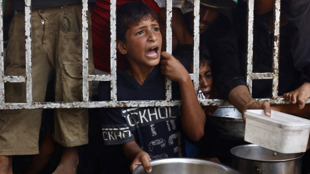 Des enfants palestiniens attendent leur repas dans une cantine sociale du quartier de Mawasi, à Khan Yunis, dans le sud de la bande de Gaza, le 22 juillet 2025.