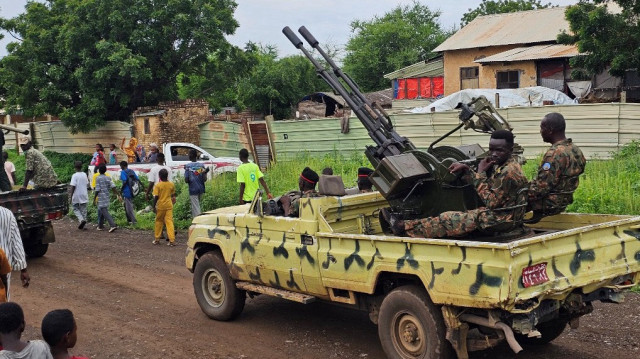 Des enfants passent devant un défilé de l'armée soudanaise dans les rues de Gedaref, dans l'est du Soudan, le 14 août 2025, à l'occasion du 71e anniversaire de la création de l'armée soudanaise. Depuis son début en avril 2023, la guerre au Soudan entre l'armée régulière et son rival paramilitaire, les Forces de soutien rapide (RSF), a fait des dizaines de milliers de morts et contraint des millions de personnes à fuir leurs foyers.