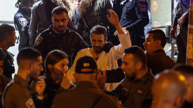Les forces de sécurité israéliennes arrêtent un militant anti-gouvernemental devant le siège du parti Likoud à Tel Aviv lors d'une manifestation appelant à la démission du gouvernement, le 28 mai 2025.